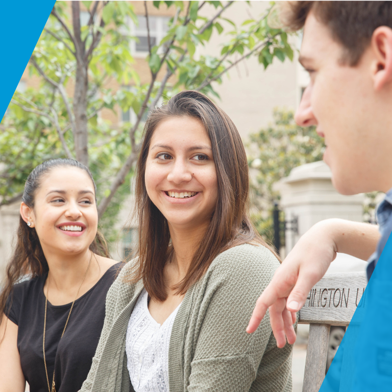 three gw students sit on a bench on campus in nice weather
